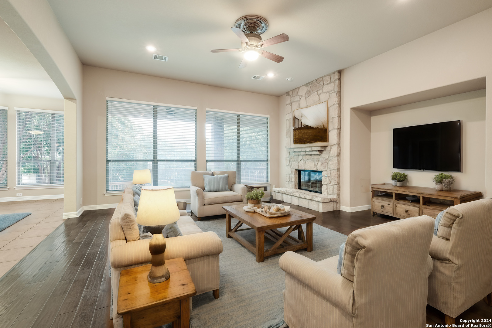 a living room with furniture flat screen tv and a large window