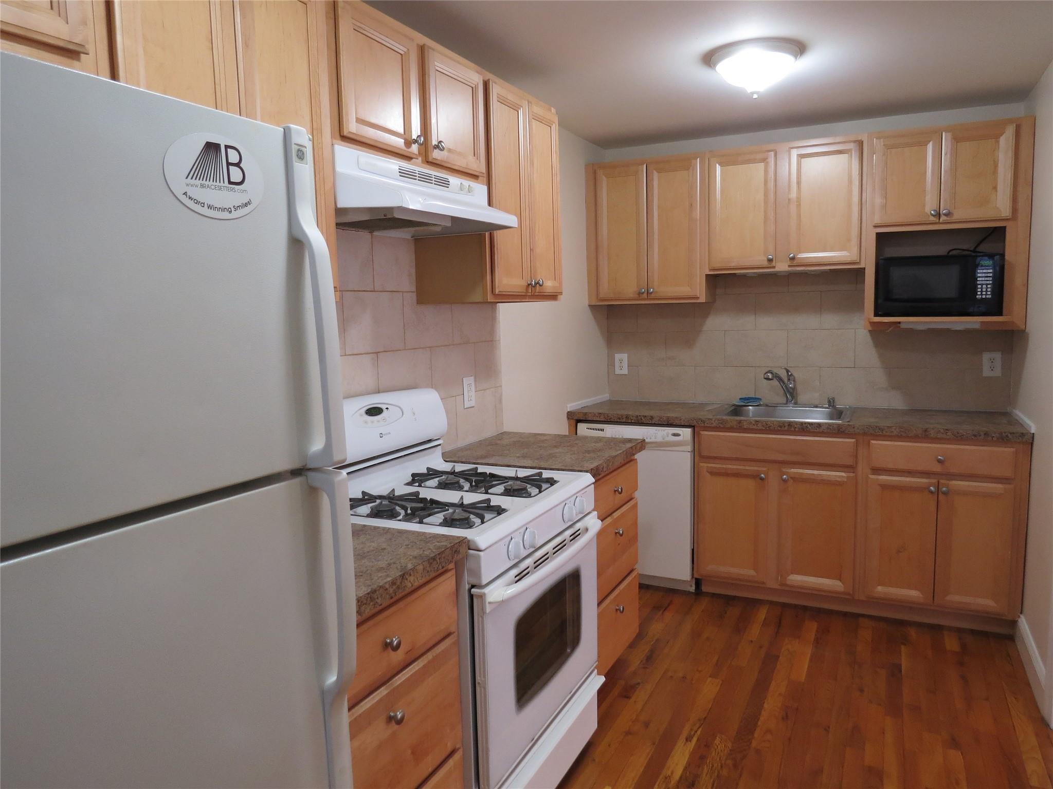 a kitchen with granite countertop a sink stove and refrigerator