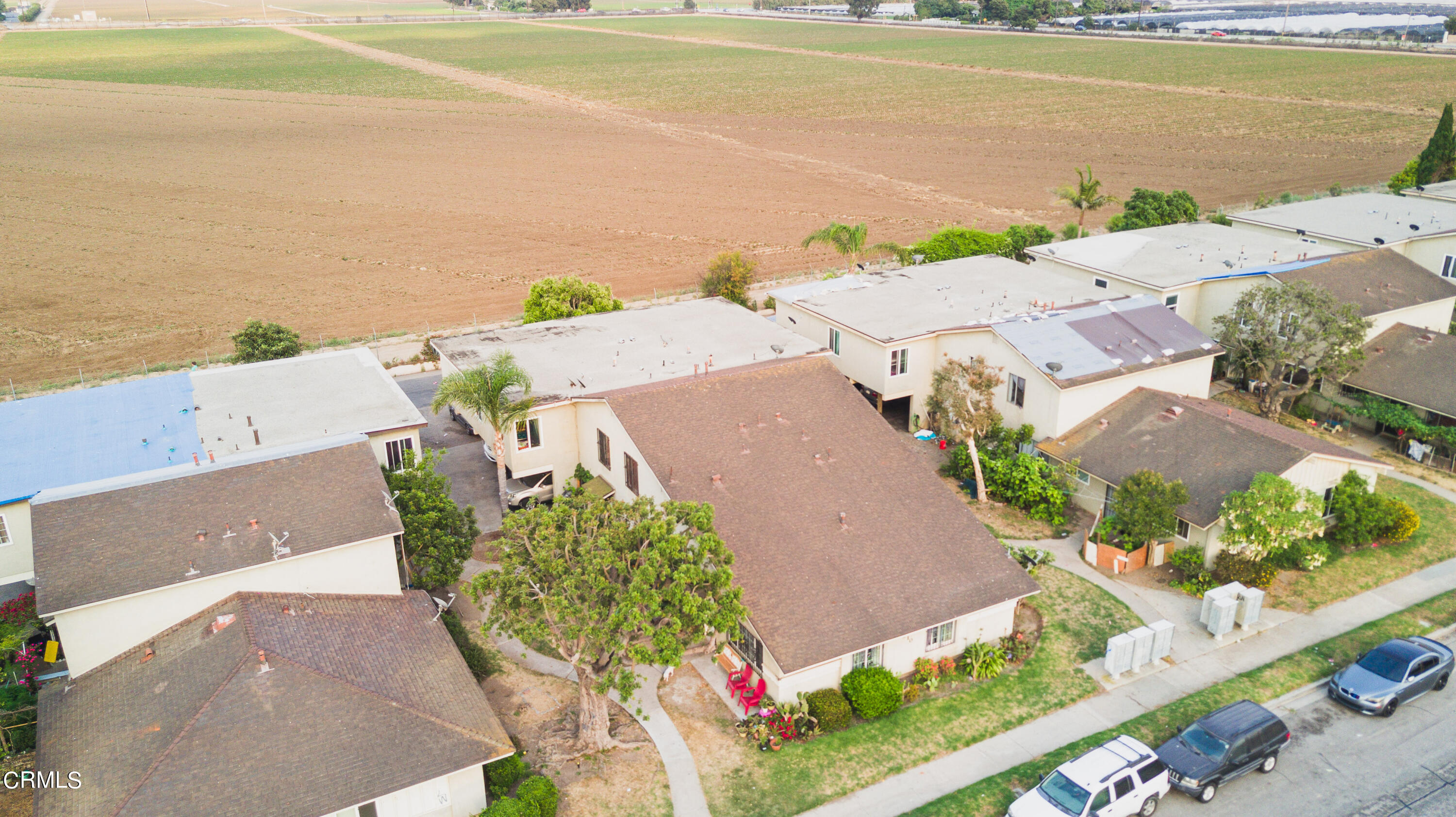 an aerial view of ocean and residential houses with outdoor space