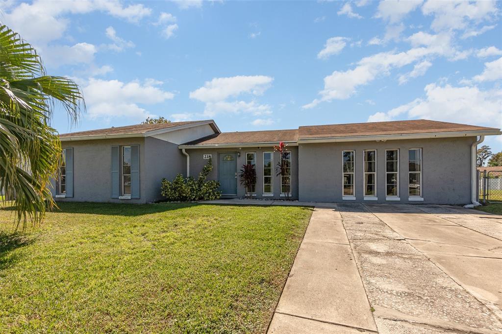 a front view of house with yard and trees in the background