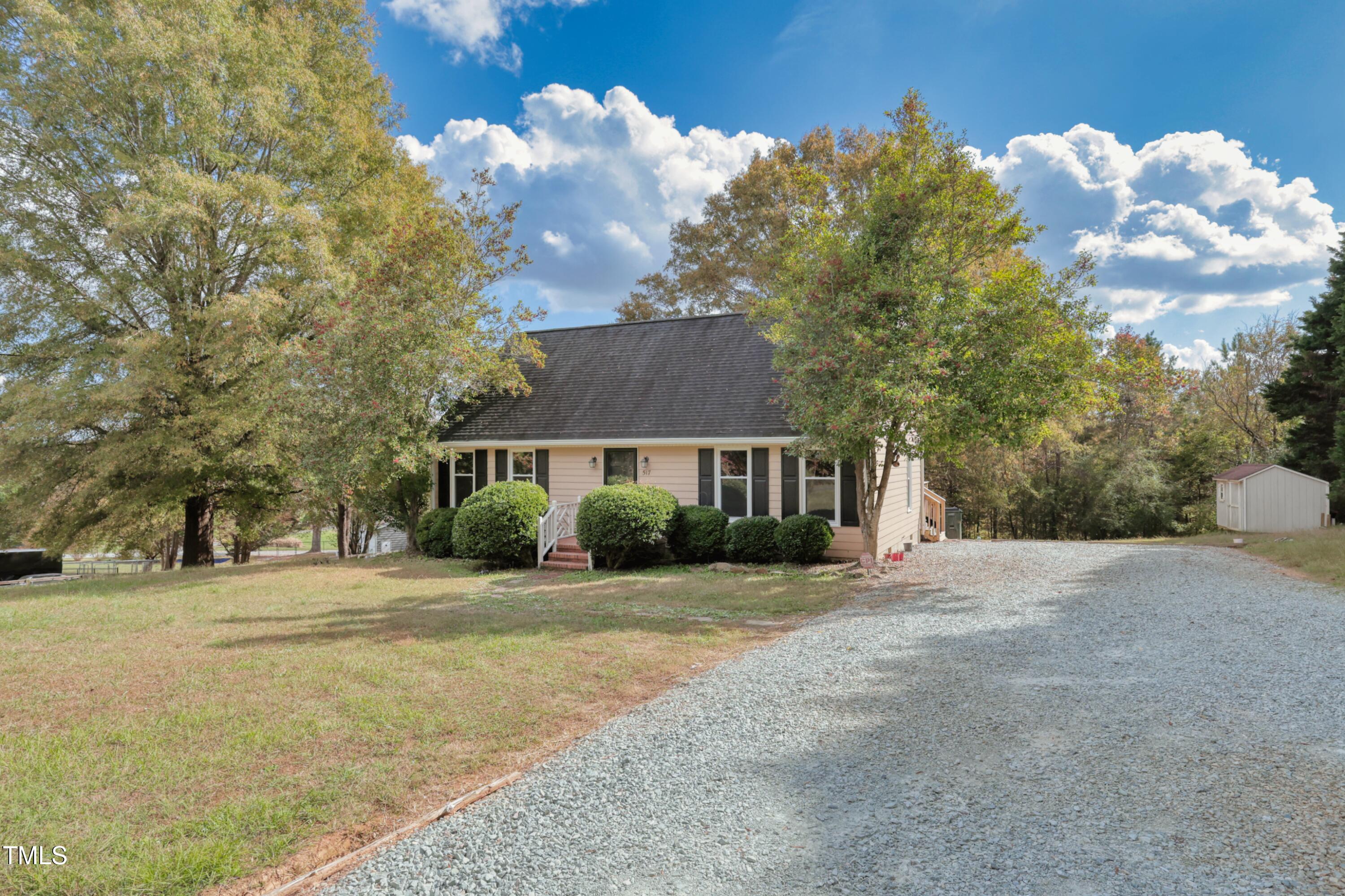 a front view of a house with a yard and trees