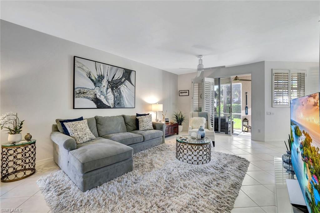 a living room with furniture and a floor to ceiling window