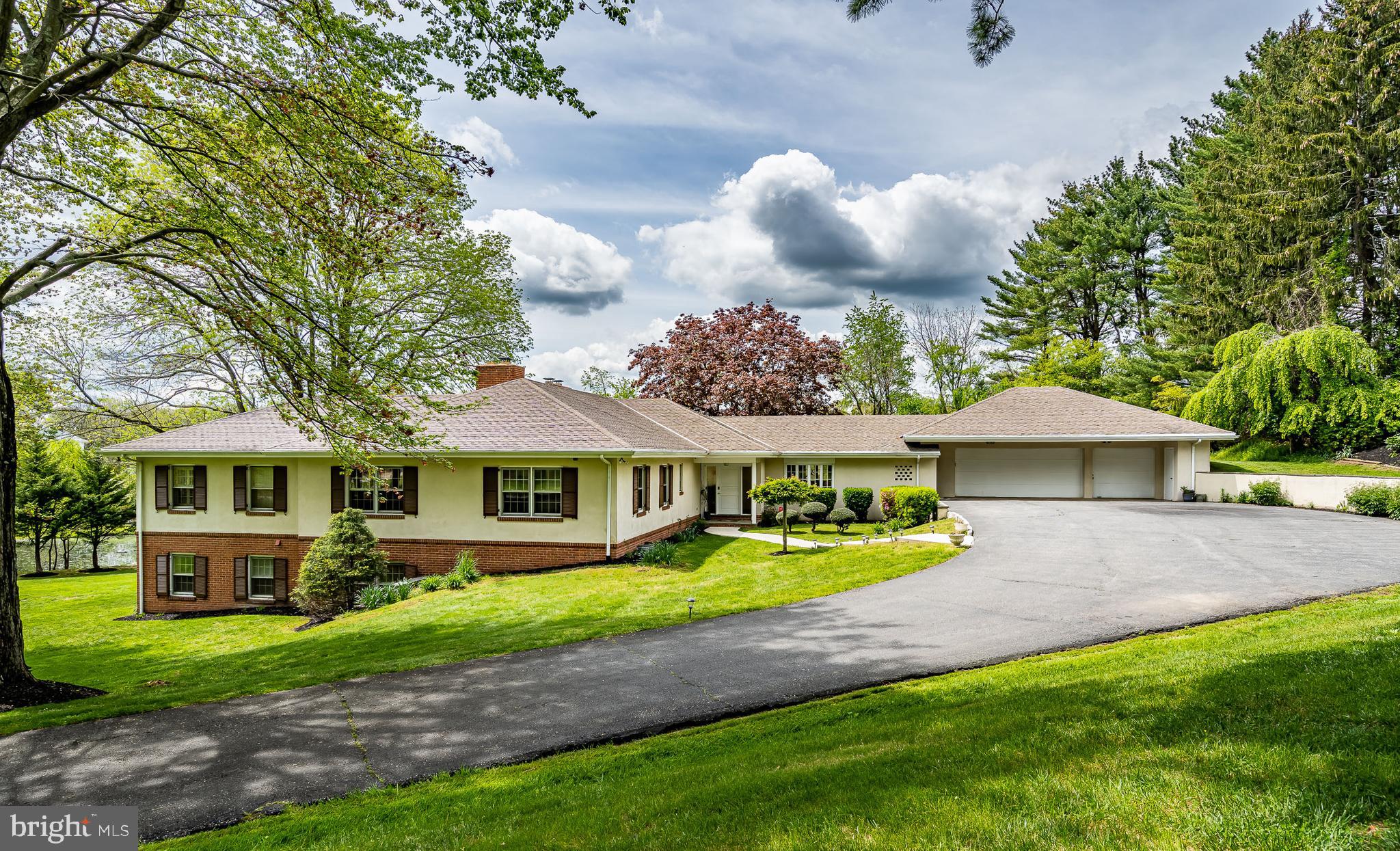 a front view of a house with a yard and trees