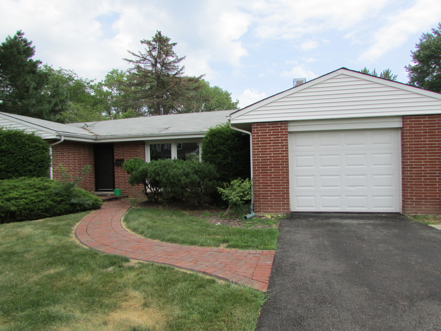 a front view of a house with a garden and yard