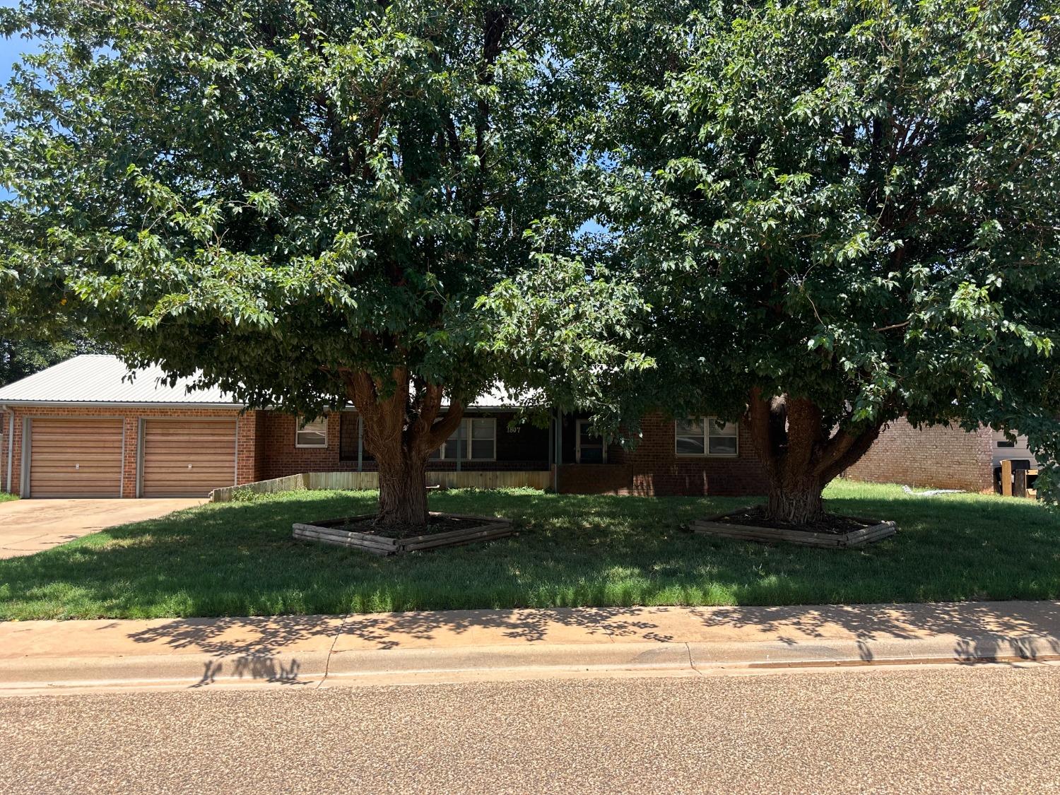 a front view of a house with a yard and trees