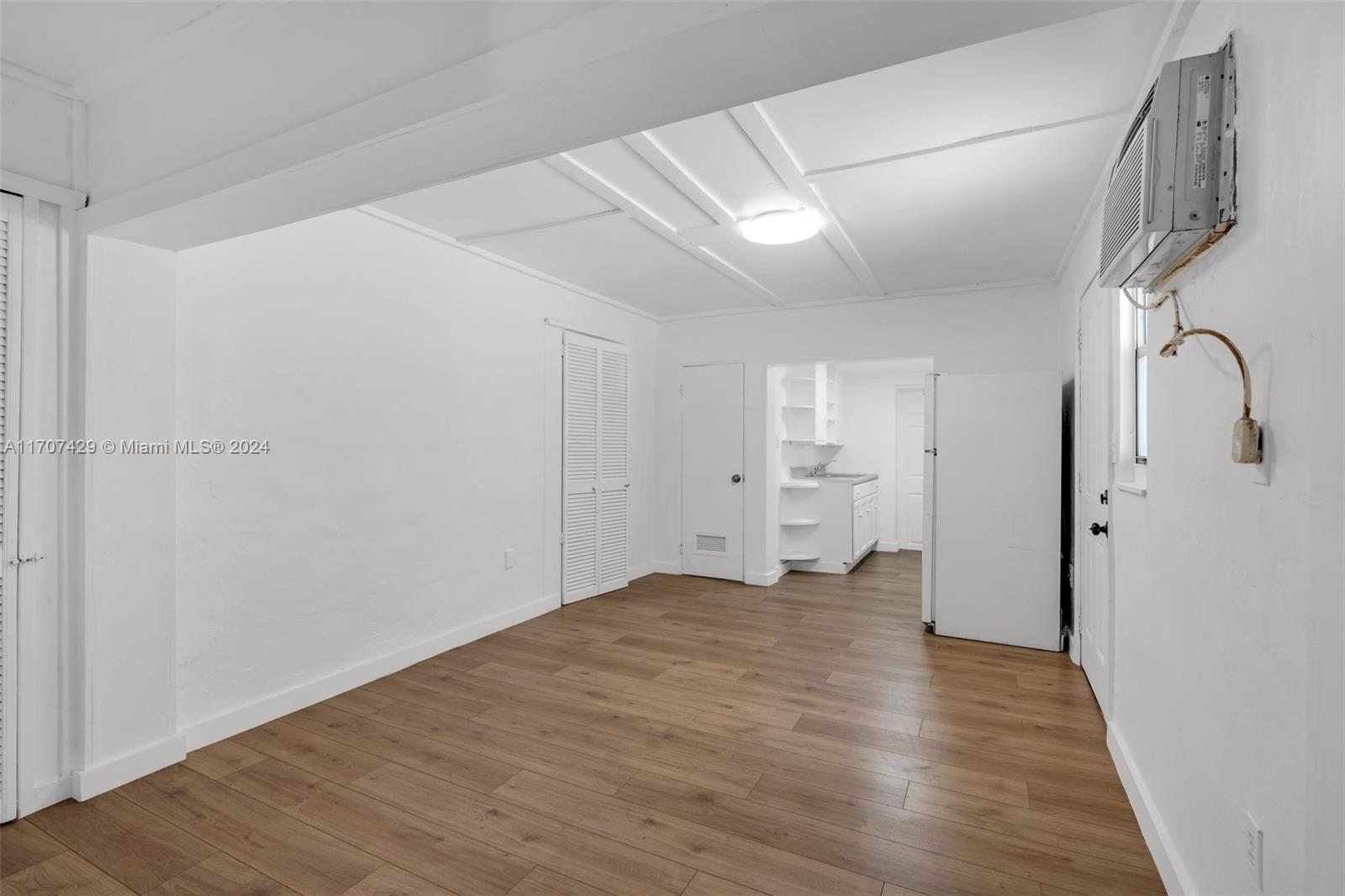 a view of empty room with wooden floor and window