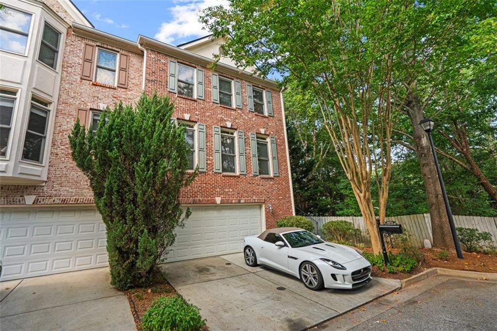 a car parked in front of a brick house with large windows