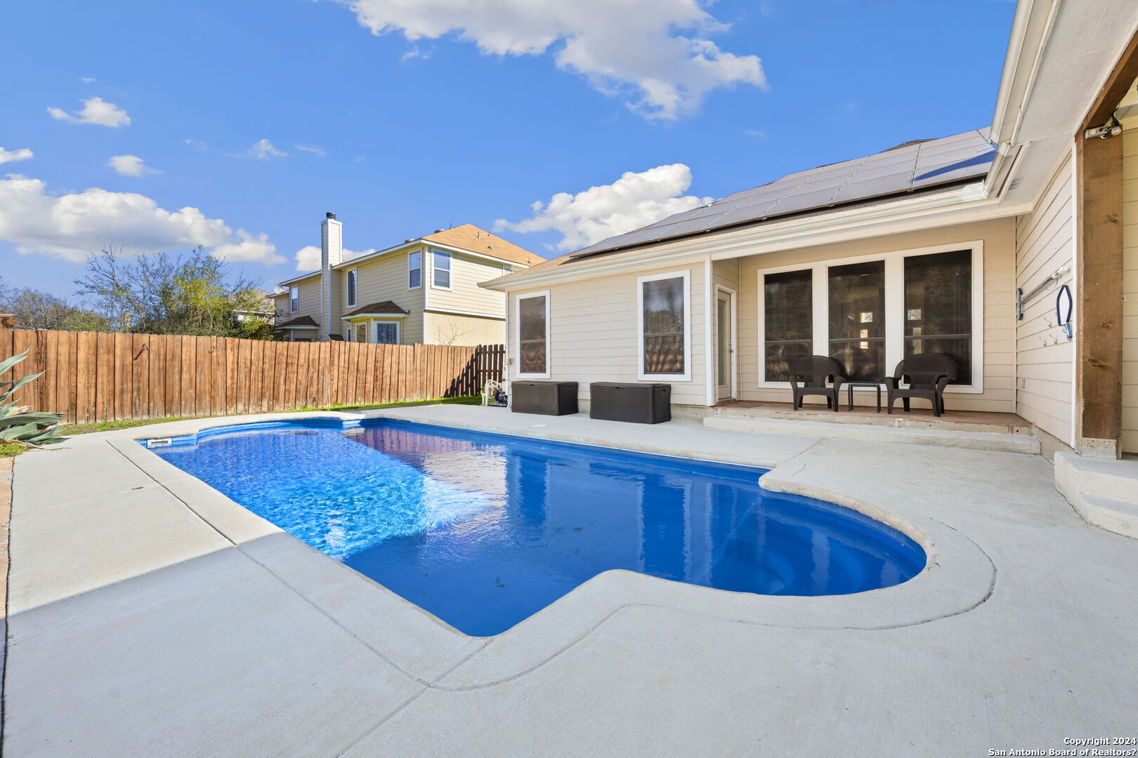 a view of a house with pool and sitting area