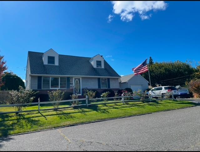 New england style home featuring a front yard