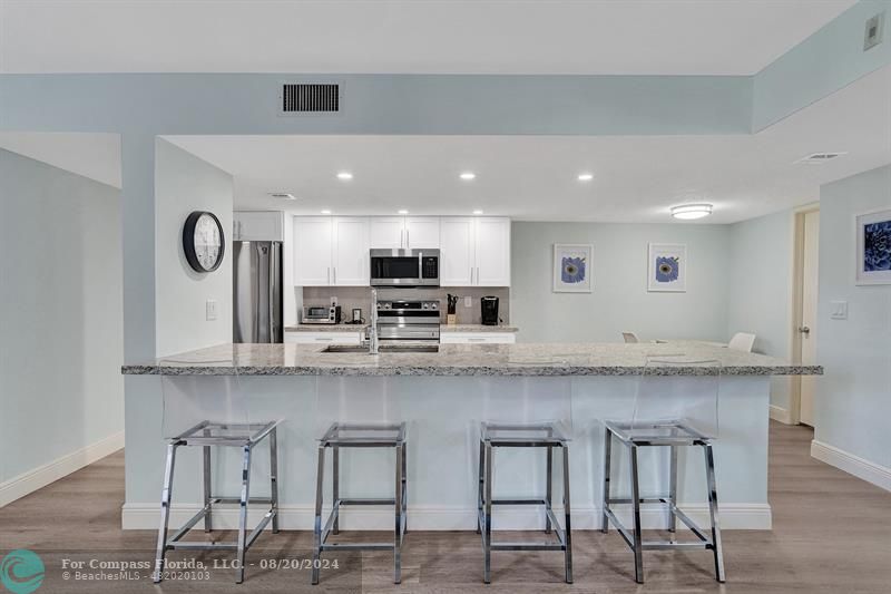 a large white kitchen with lots of counter space and window