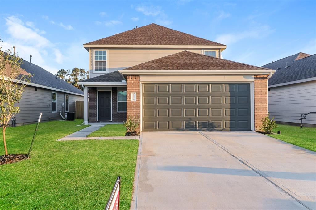 a front view of a house with a yard and garage