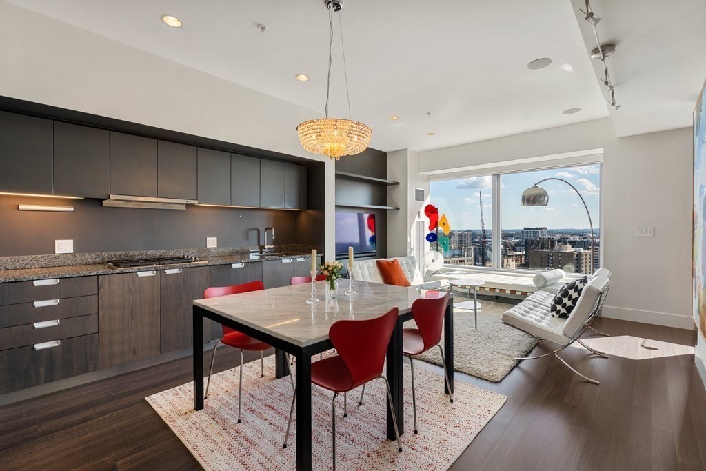 a kitchen with a dining table cabinets stainless steel appliances and a chandelier