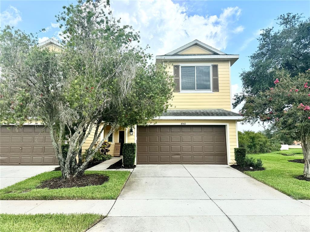 a front view of a house with a yard and trees