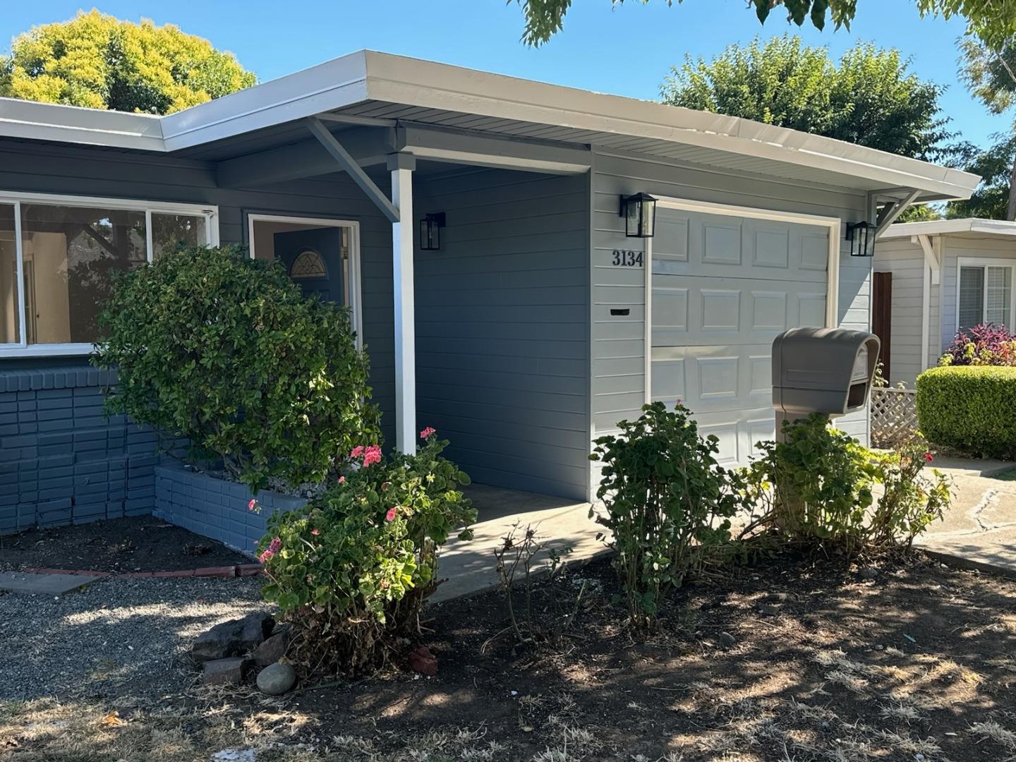 a view of a house with a yard and potted plants