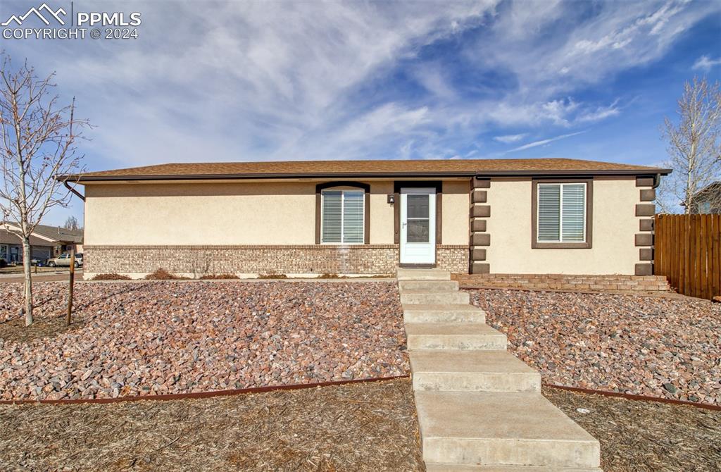 a front view of a house with a yard and mountain view