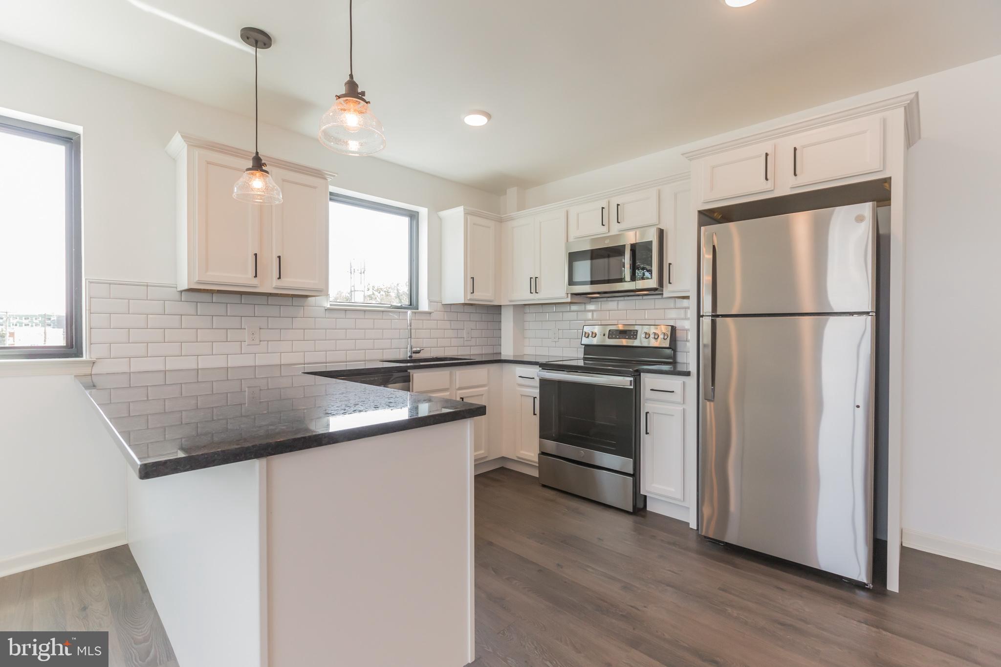 a kitchen with a sink a refrigerator a microwave and cabinets