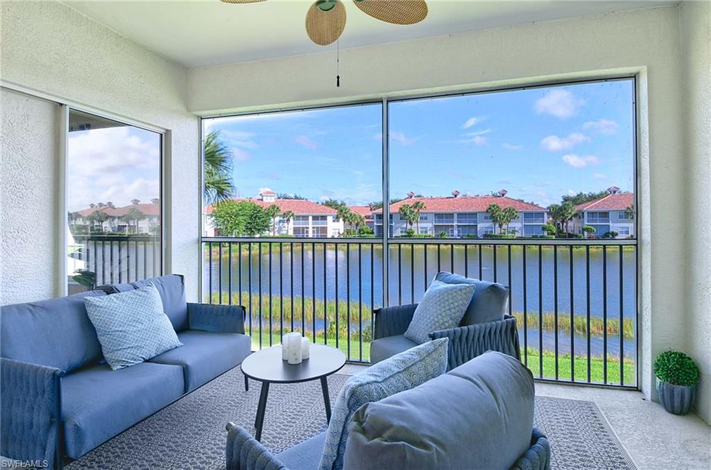 Sunroom featuring ceiling fan and a water view