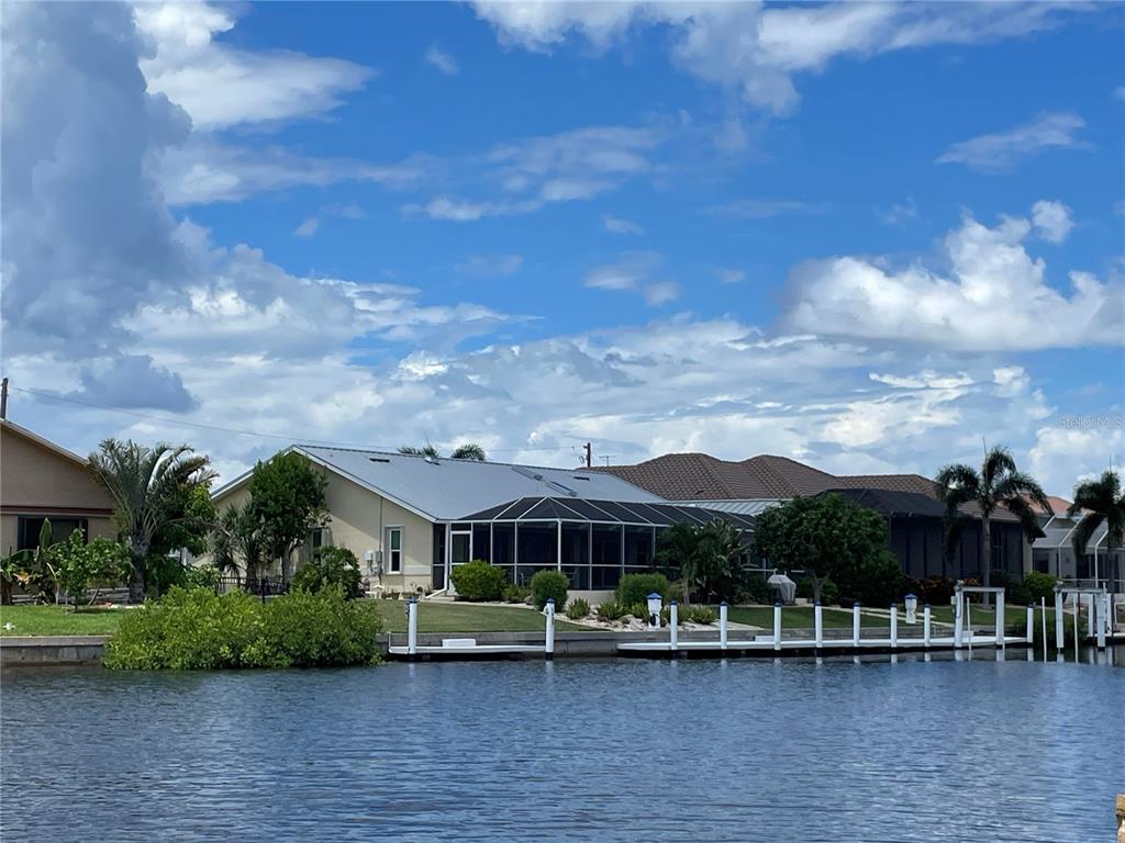 a front view of a house with a garden and lake view