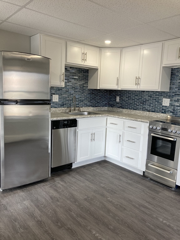 a kitchen with granite countertop white cabinets and stainless steel appliances