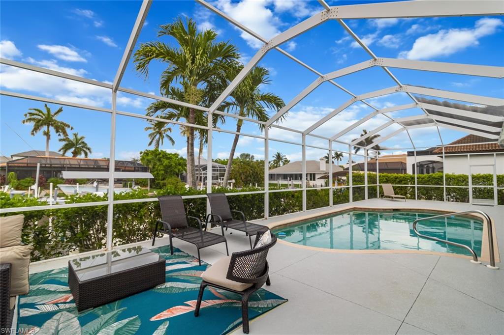 a view of a swimming pool with couches chairs and potted plants