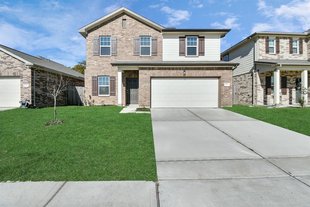 a front view of a house with a yard and garage