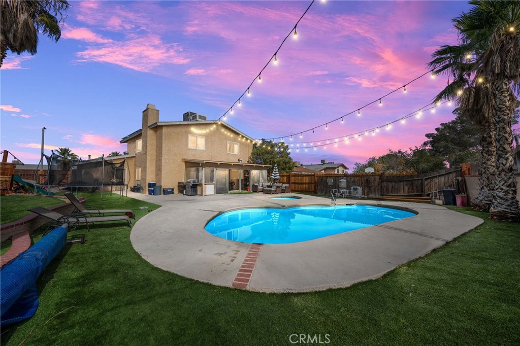 a view of a house with swimming pool and yard