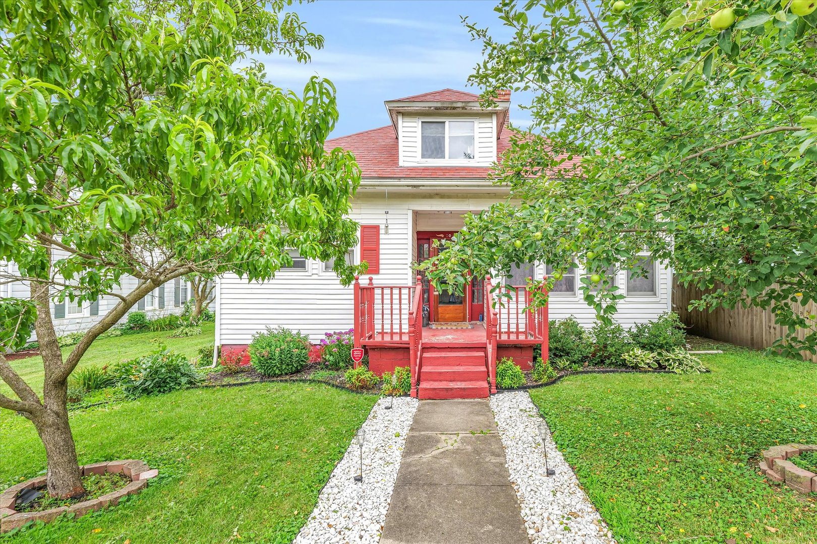 a front view of a house with a yard and trees