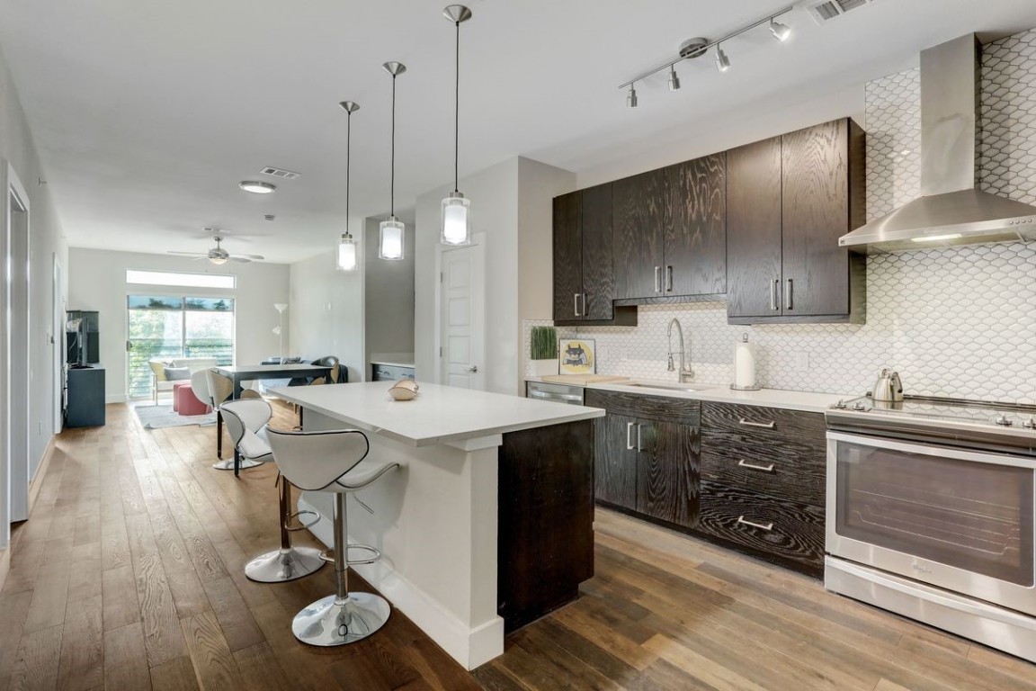 a kitchen with a sink a stove and chairs