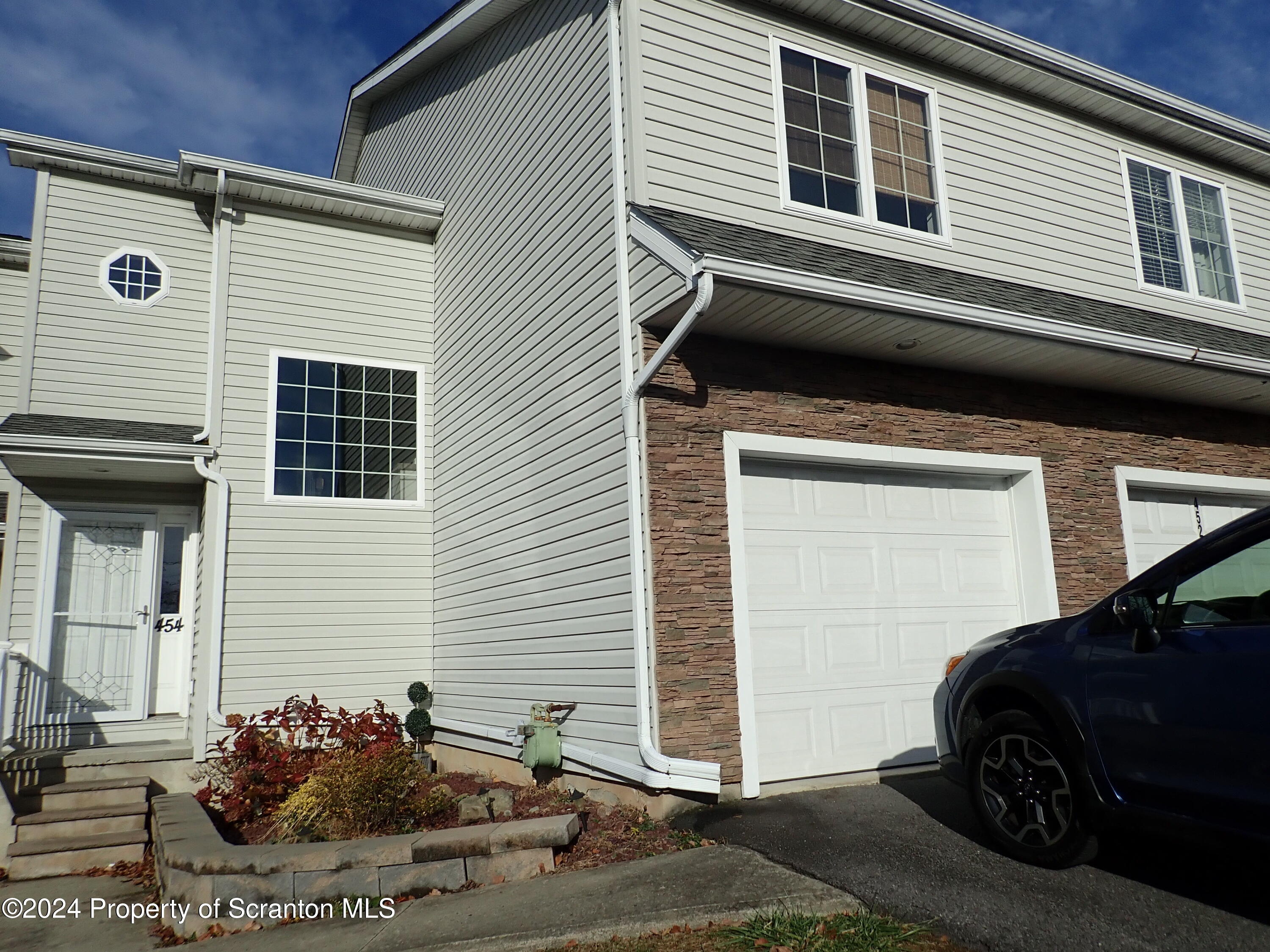 a view of a house with a car parked in front of it