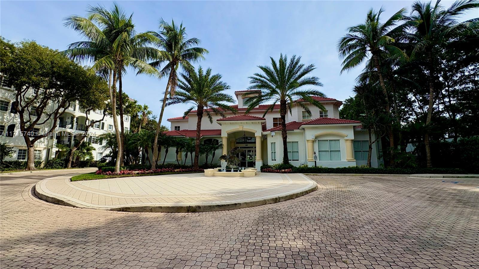 a view of a white house with a yard and palm trees