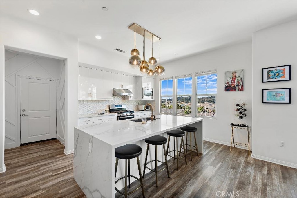 a kitchen with kitchen island a wooden floor and white appliances