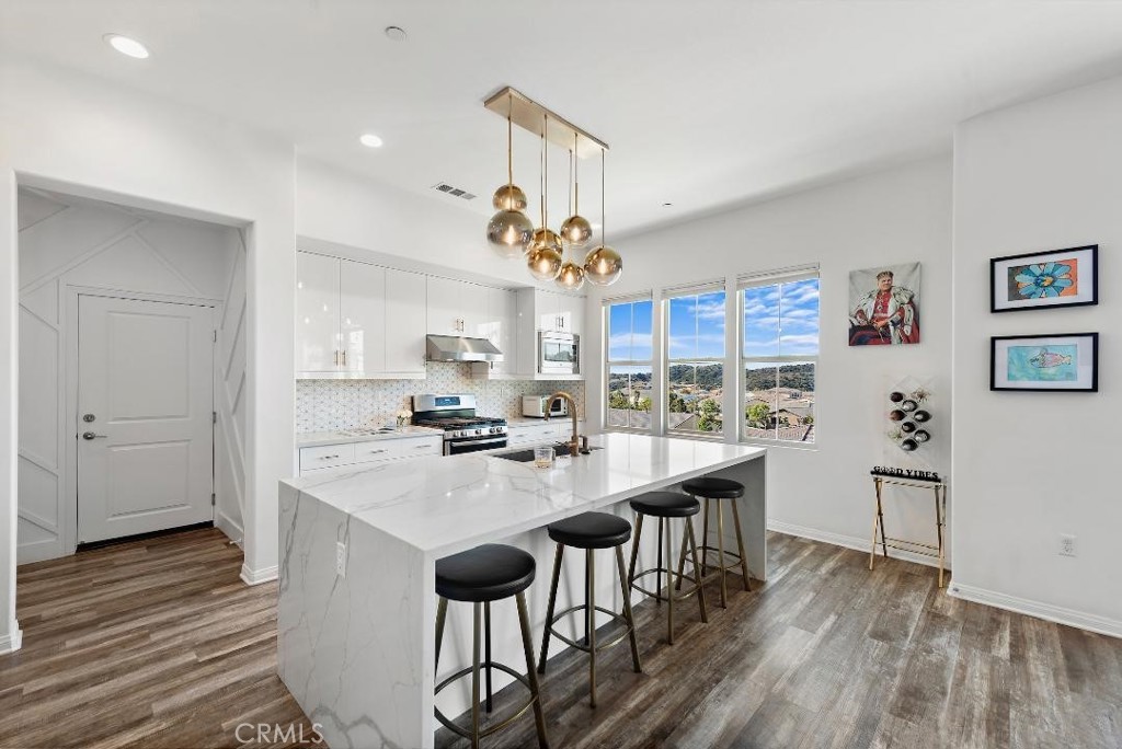 a kitchen with kitchen island a wooden floor and white appliances