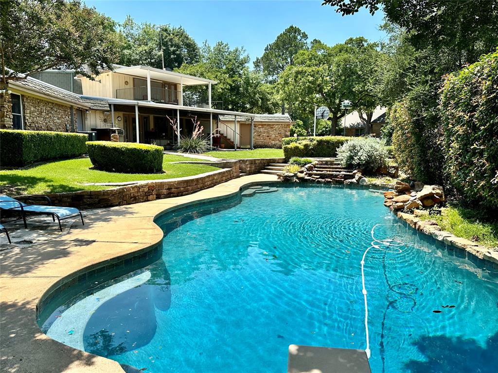 a view of a house with backyard swimming pool and sitting area