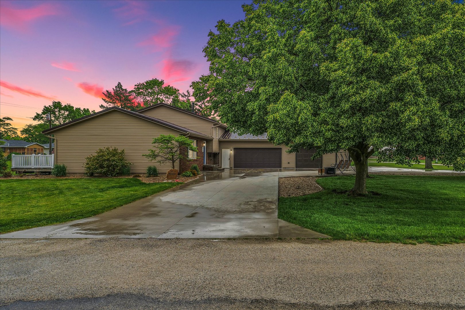 a front view of a house with a garden and trees