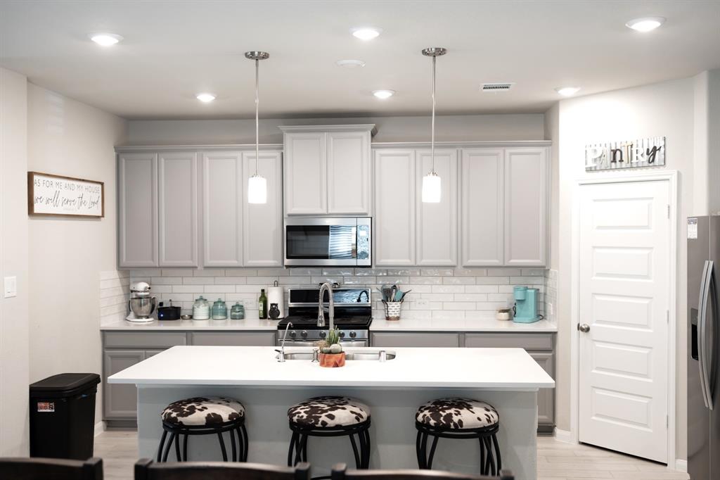 a kitchen with stainless steel appliances a stove a sink and a refrigerator