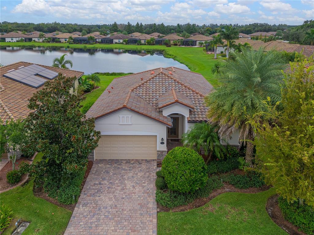 an aerial view of a house with outdoor space and a lake view in back