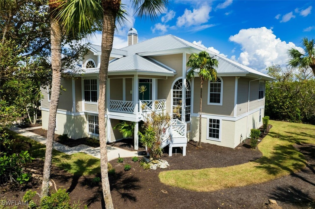 a view of a white house with many windows plants and palm trees