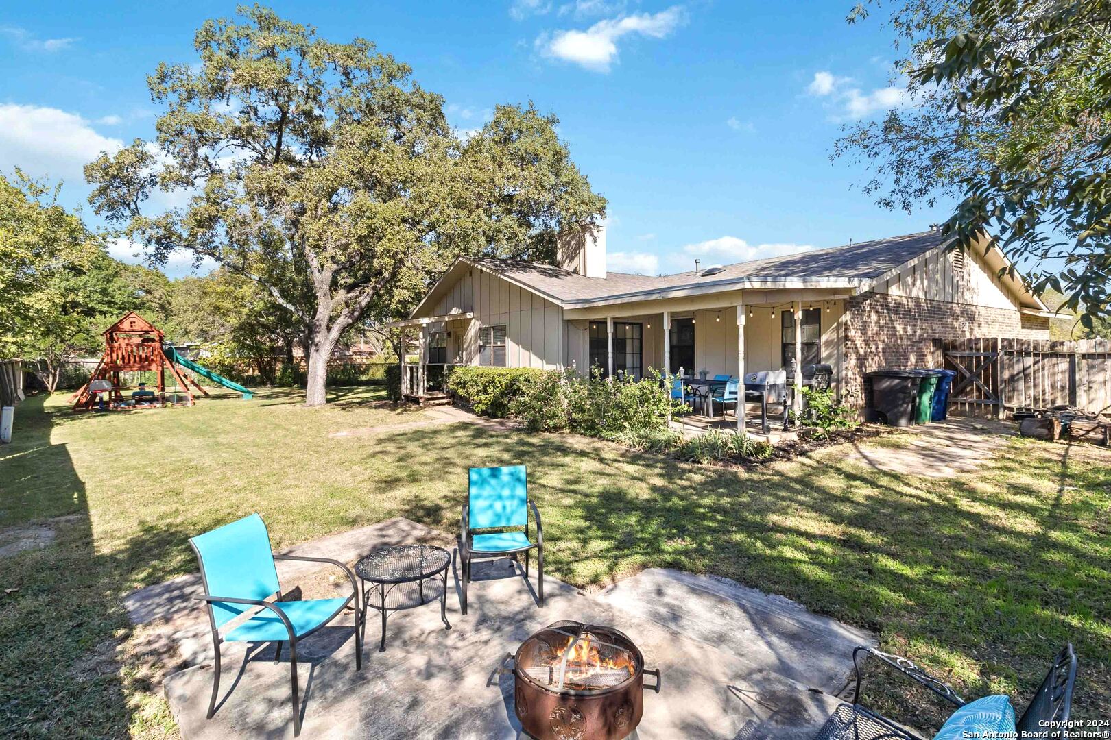 a view of a house with backyard and sitting area