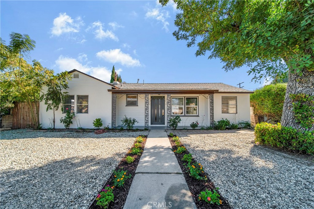 a front view of a house with a yard and potted plants