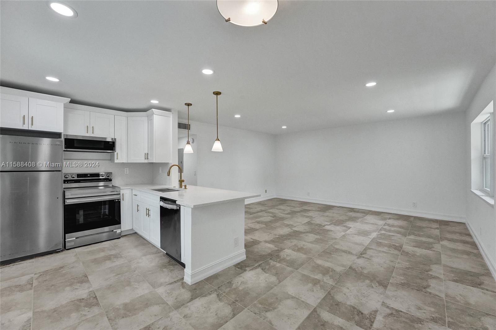 a kitchen with kitchen island granite countertop a stove a sink and a refrigerator