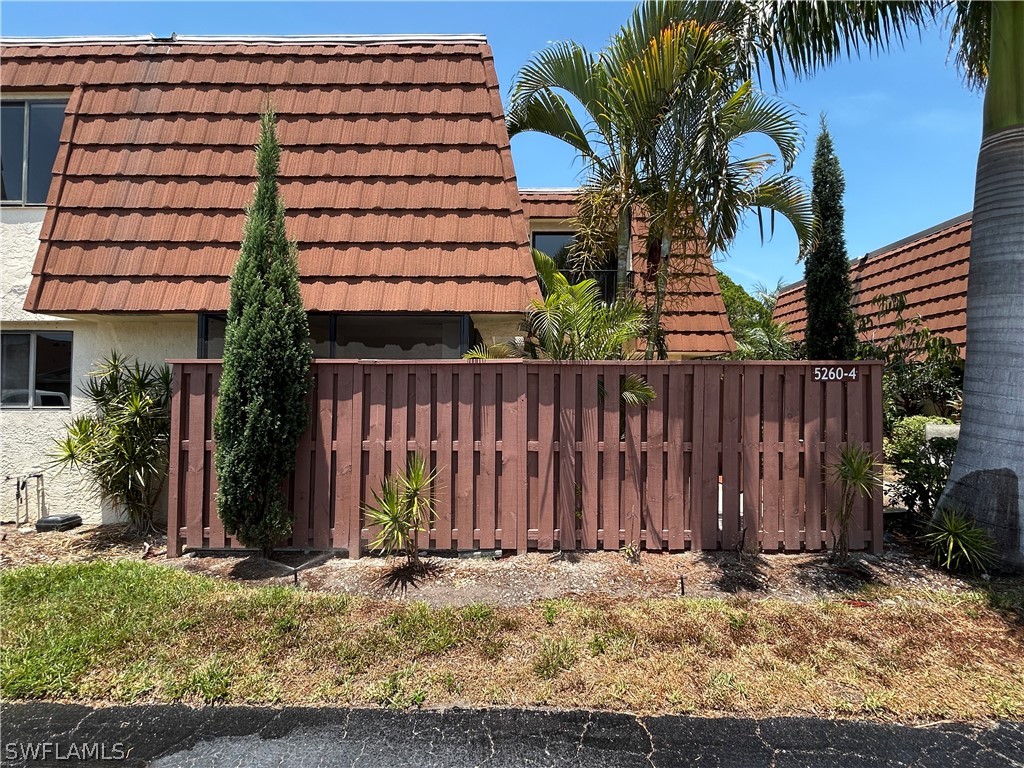 a backyard of a house with barbeque oven and plants