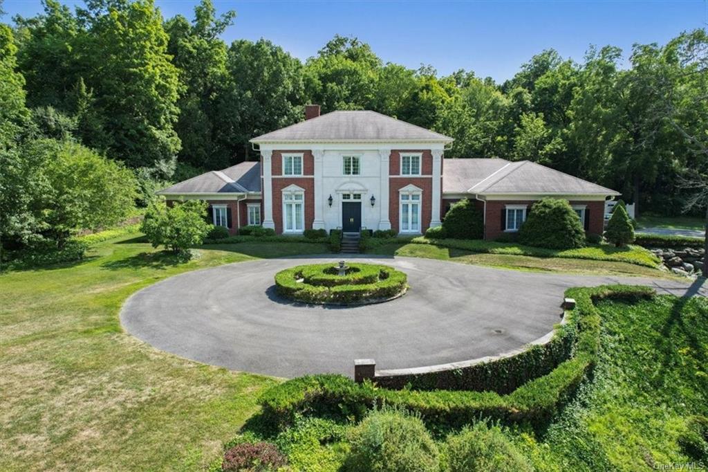 a front view of a house with yard and green space