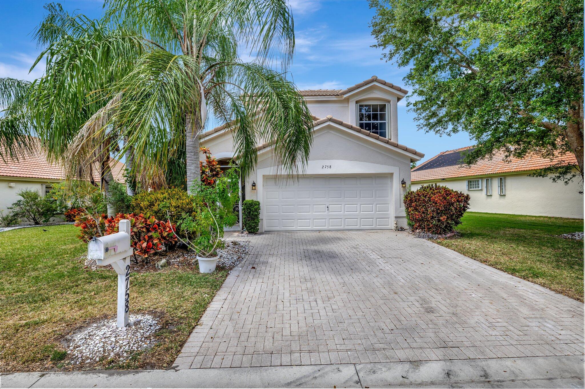 a front view of a house with a yard and a garage