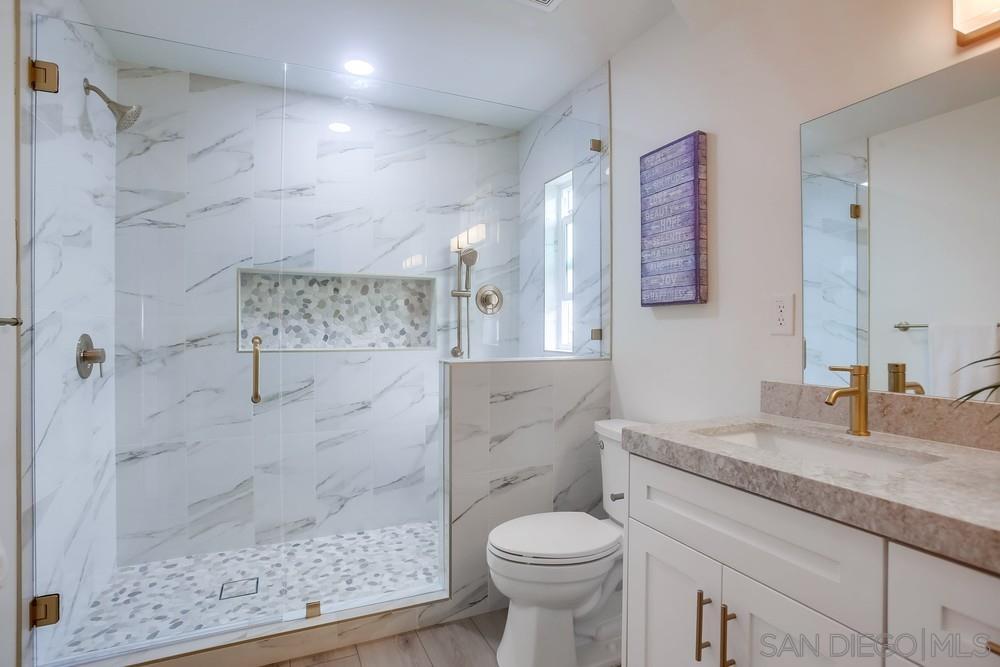 a bathroom with a granite countertop sink toilet and shower