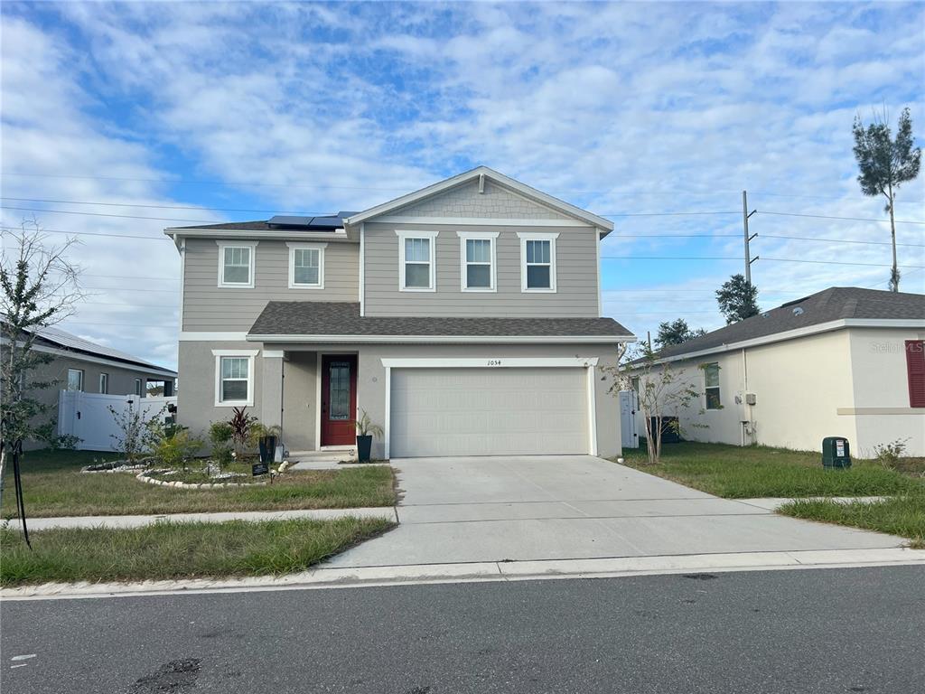 a front view of a house with a yard and garage