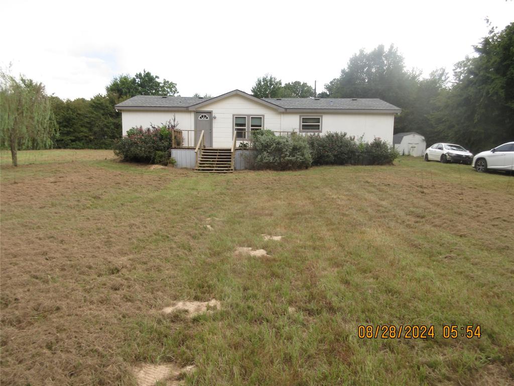 a front view of a house with a yard and trees