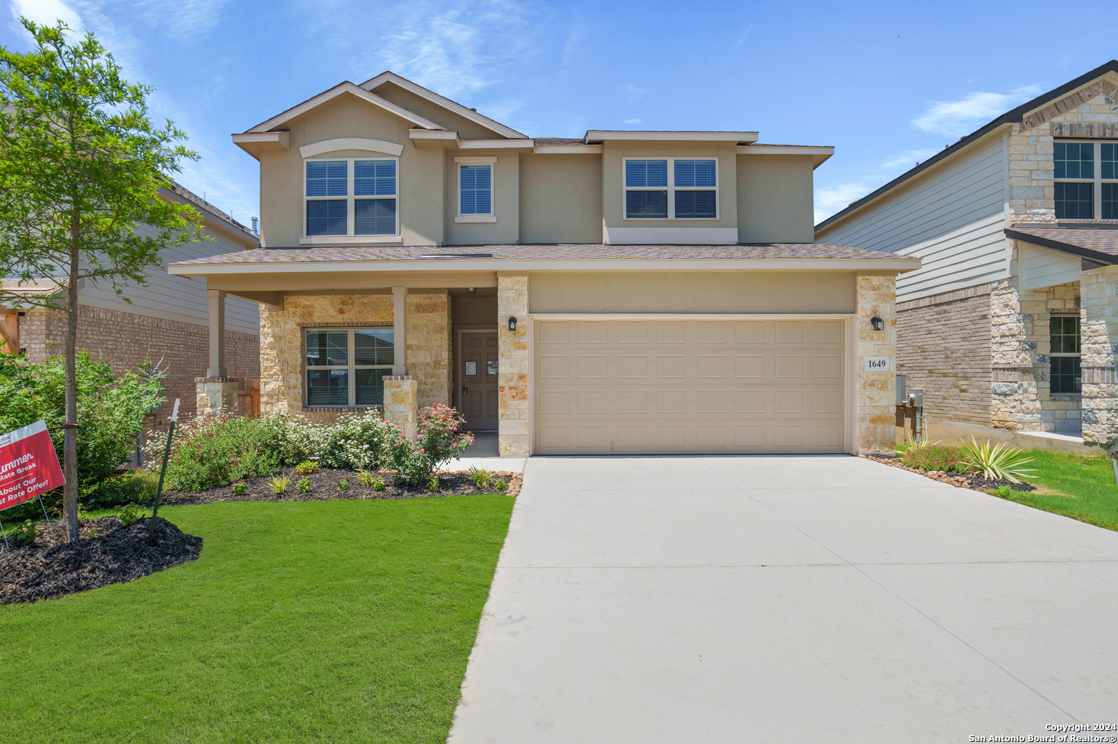 a front view of a house with a yard and garage