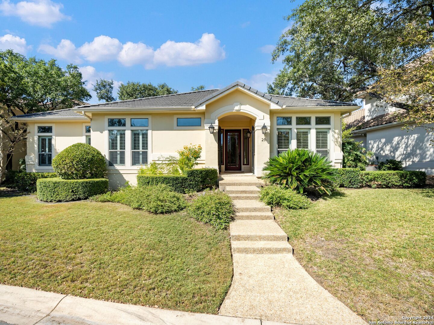 a front view of a house with yard and green space