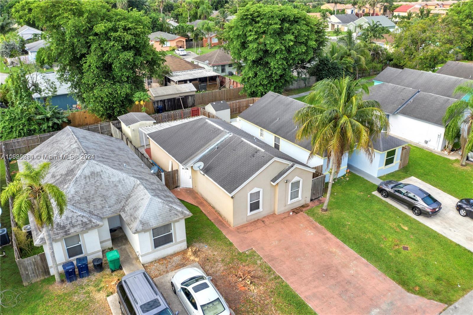 an aerial view of multiple houses with a yard