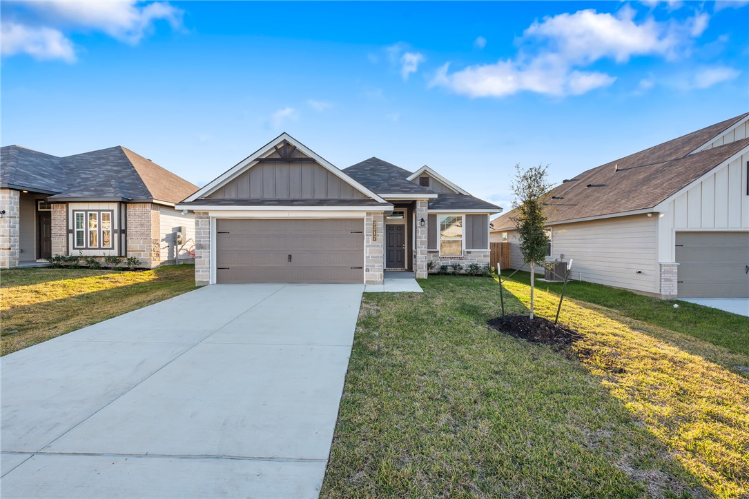 Craftsman house with a garage and a front lawn